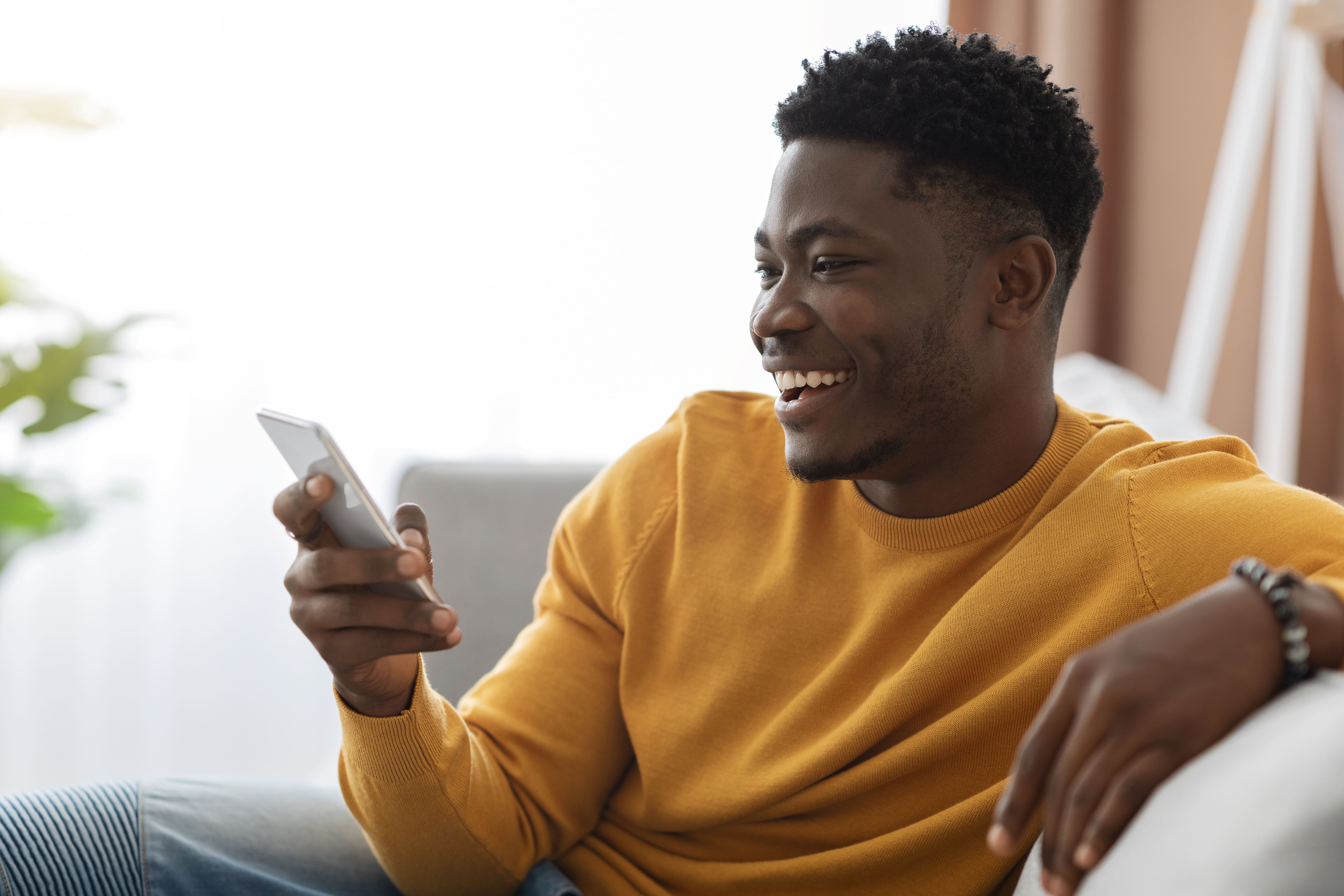 Chico feliz chateando con su novia usando el móvil