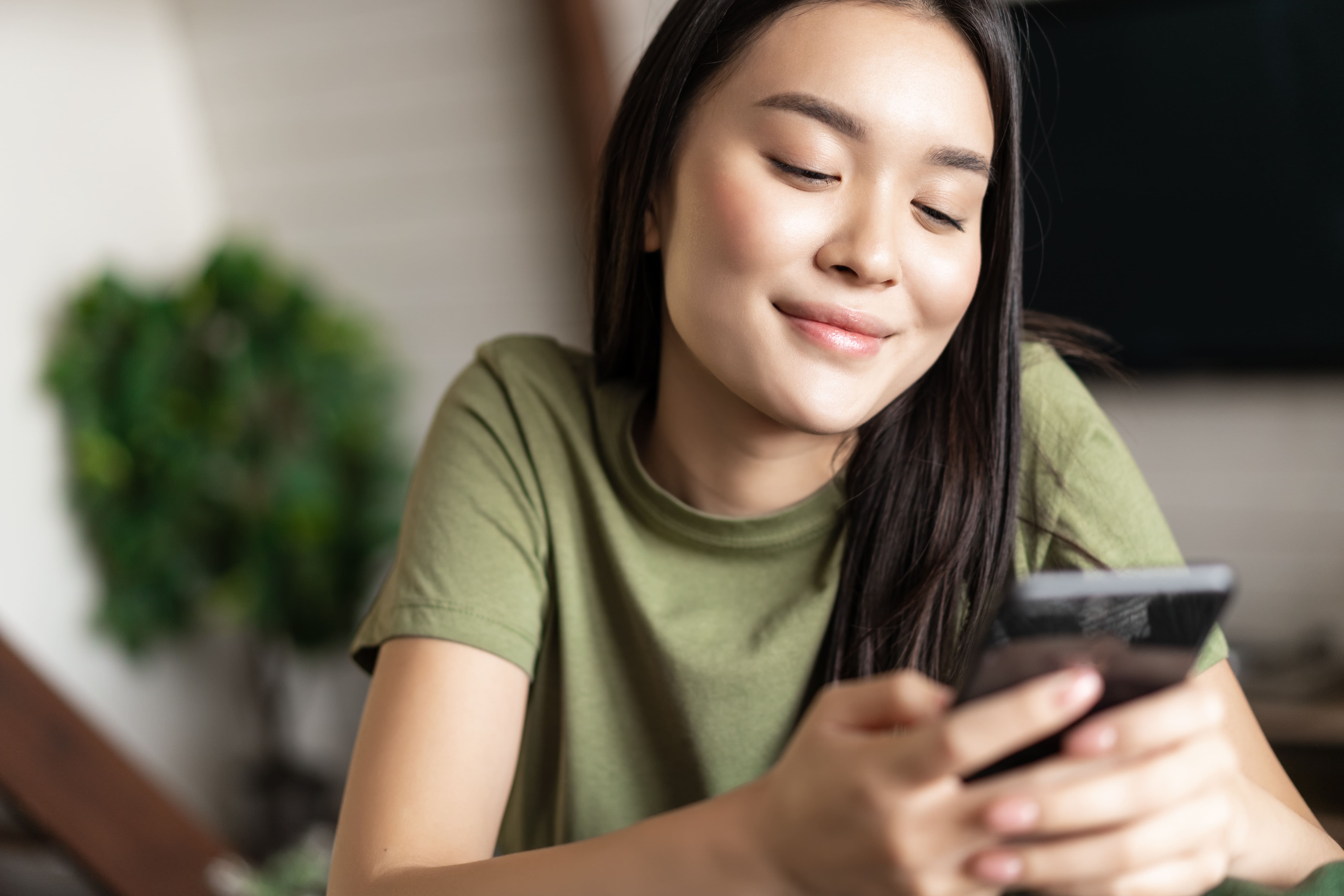 Mujer sonriente usando un teléfono